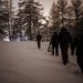 Groupe d'hommes marchant dans une forêt enneigée